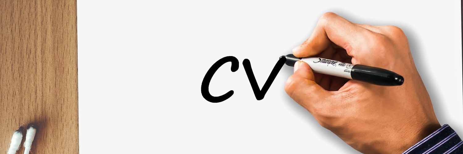 Mano de hombre escribiendo las letras CV sobre un papel en blanco.